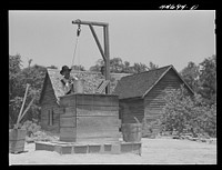 [Untitled photo, possibly related to: Allen Mathews drawing water from his well. FSA (Farm Security Administration) borrower. Near Greshamville, Greene County, Georgia]. Sourced from the Library of Congress.