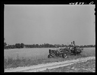 The government bought this wheat from a farmer who had to move out of the Army camp area. It was then sold to a contractor. Contractor's combine harvesting wheat. Caroline County, Virginia. Sourced from the Library of Congress.