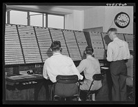 [Untitled photo, possibly related to: In the airport control room with which incoming and outgoing airliners are in constant communication. Flight data is kept on the white slips of cardboard. A new electrical control board just completed on the opposite side of the room will replace this one Washington, D.C. municipal airport]. Sourced from the Library of Congress.