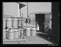 [Untitled photo, possibly related to: Loading milk cans into a truck at the United Farmers' Co-op Creamery at East Berkshire, Vermont]. Sourced from the Library of Congress.
