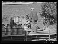 [Untitled photo, possibly related to: Farmer unloading milk cans at the United Farmers' Co-op Creamery. East Berkshire, Vermont]. Sourced from the Library of Congress.