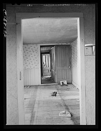 Interior of abandoned house in what used to be Lewisburg, New York in the Pine Camp expansion area near Watertown, New York. Sourced from the Library of Congress.