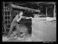 Stirring paper pulp in a large vat at the Mississquoi Corporation paper mill in Sheldon Springs, Vermont. Sourced from the Library of Congress.