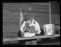 [Untitled photo, possibly related to: Boyd Jones washing his face on the back porch of his house, Greene County, Georgia]. Sourced from the Library of Congress.