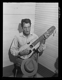 [Untitled photo, possibly related to: Corozal, Puerto Rico (vicinity). Musician in the orchestra which furnished the music for dancing at the tenant purchase celebration. He is playing a "cuatro," a four-stringed guitar]. Sourced from the Library of Congress.