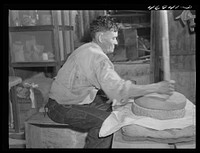 [Untitled photo, possibly related to: Frederiksted (vicinity), Saint Croix Island, Virgin Islands. Puerto Rican farmer grinding corn with stones he brought with him from Puerto Rico]. Sourced from the Library of Congress.