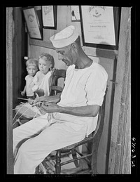 French village, a small settlement on Saint Thomas Island, Virgin Islands. A seaman who makes extra money weaving straw objects which are sold at the handicrafts cooperative. Sourced from the Library of Congress.