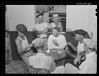 French Village, a small settlement on Saint Thomas Island, Virgin Islands. A group of card players in the one tavern and general store. Sourced from the Library of Congress.