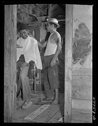 San Juan, Puerto Rico. A barber shop in the huge slum area known as "El Fangitto." The barber is a former radio mechanic and farmer. Sourced from the Library of Congress.