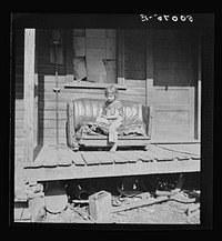 Child on front porch in abandoned mining town. Jere, West Virginia. See 30221-M1. Sourced from the Library of Congress.