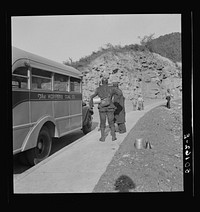 Coal miners waiting along road for bus to take them home. In Welch, Bluefield section, West Virginia. Sourced from the Library of Congress.