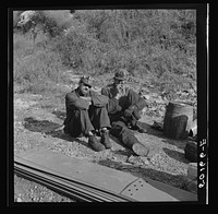 Coal miners waiting along road for bus to take them home. In Welch, Bluefield section, West Virginia. Sourced from the Library of Congress.