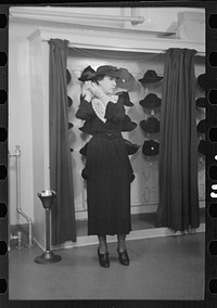 [Untitled photo, possibly related to: Model trying on hat for a buyer, New York City showroom, Jersey Homesteads cooperative] by Russell Lee