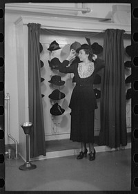 [Untitled photo, possibly related to: Model trying on hat for a buyer, New York City showroom, Jersey Homesteads cooperative] by Russell Lee