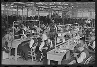 Interior of cooperative garment factory at Jersey Homesteads, showing some of eighty homesteaders at their work and some of the ladies' coats made by them. Hightstown, New Jersey by Russell Lee