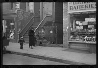[Untitled photo, possibly related to: Mothers talking together and child playing in the gutter, 139th Street just east of St. Anne's Avenue, Bronx, New York] by Russell Lee