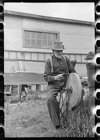 Old resident of Winton, Minnesota, sharpening an axe by Russell Lee