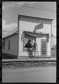 Girl washing windows of cafe, Cook, Minnesota by Russell Lee