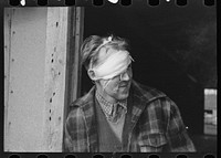 Lumberjack with bandaged head after being beaten up and "rolled" in a saloon on Saturday night in Craigville, Minnesota by Russell Lee