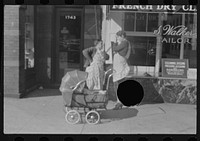 [Untitled photo, possibly related to: Women with baby carriage, L Street, Washington, D.C.] by Russell Lee
