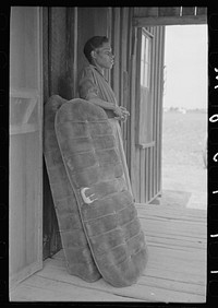 FSA (Farm Security Administration) client, former sharecropper, on front porch of shack. Southeast Missouri Farms by Russell Lee