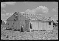 Barn erection. Beginning prime coating of completely erected barn in field. Southeast Missouri Farms Project by Russell Lee