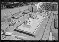 House plant. Fitting windows and siding to the wall panels. Note framing tables and stacks of window and door inserts at the left. Southeast Missouri Farms Project by Russell Lee