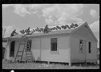 [Untitled photo, possibly related to: Southeast Missouri Farms Project. House erection. Shingling crew at work on roof. Shingles are tucked in roof lath to keep them from blowing away] by Russell Lee