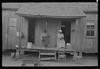 Old  couple sitting on front porch of shack home, Southeast Missouri Farms by Russell Lee