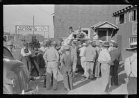 Group of farmers at peach auction, Sikeston, Missouri by Russell Lee