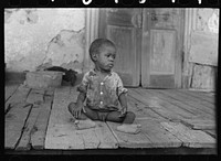 Child on porch of dilapidated Trepagnier plantation near Norco, Louisiana by Russell Lee