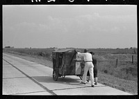 Traveling evangelists pushing cart on road between Lafayette and Scott, Louisiana by Russell Lee