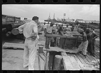  stevedores loading stove onto packet boat under supervision of captain, Burrwood, Louisiana by Russell Lee