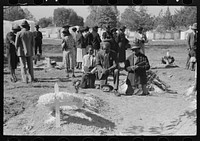  family praying at graves of their relatives on All Saints' Day, New Roads, Louisiana by Russell Lee