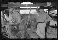 [Untitled photo, possibly related to: Owner atop his turpentine still. Goosneck runs from the still to the condenser coils where vapors are chilled. State Line, Mississippi] by Russell Lee