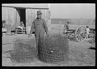 Sharecropper with wire which he has rolled up after taking down fences on his rented farm, Transylvania Project, Louisiana by Russell Lee