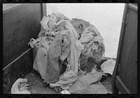 Pile of raggedy clothing in tent home of migrants near Harlingen, Texas by Russell Lee