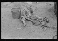 Child of white migrant worker playing with automobile tools near Harlingen, Texas by Russell Lee