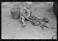 [Untitled photo, possibly related to: Child of white migrant worker playing with automobile tools near Harlingen, Texas] by Russell Lee