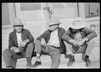 Residents of Crystal City, Texas sitting on steps of store by Russell Lee