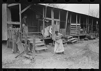 Corral, woman sweeping up trash, San Antonio, Texas by Russell Lee