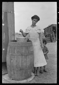 San Antonio. The Mexican section. Water supply of Mexican family living on the outskirts of town. This water is brought from the city and is delivered by wagon by Russell Lee