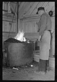 Blacksmith heating iron in forge, Southern Paper Mill construction shed, Lufkin, Texas by Russell Lee