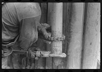 Tightening the nipple on the end of drill pipe oil field, Kilgore, Texas. This part of operation to determine direction and draft of drilling by Russell Lee