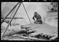 Oil field worker, probing in slush pit, Kilgore, Texas by Russell Lee