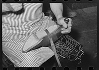 Attaching piece of leather in arch of sole by means of wooden pegs. Cowboy bootmaking shop, Alpine, Texas by Russell Lee