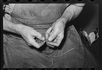 Threading a needle with waxed thread. Bootmaking shop, Alpine, Texas by Russell Lee