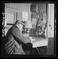 [Untitled photo, possibly related to: Freight operations on the Indiana Harbor Belt railroad between Chicago, Illinois and Hammond, Indiana. As soon as the train is under way, Conductor Cunningham gets to work on his bills and records]. Sourced from the Library of Congress.