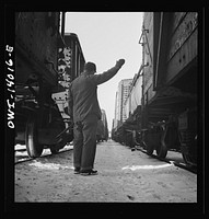 [Untitled photo, possibly related to: Freight operations on the Chicago and Northwestern Railroad between Chicago and Clinton, Iowa. The rear brakeman signals the engineer to test the brakes by applying and releasing them. This is the signal for "apply"]. Sourced from the Library of Congress.