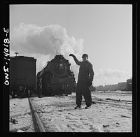 [Untitled photo, possibly related to: Freight train operations on the Chicago and Northwestern Railroad between Chicago and Clinton, Iowa. Everything is clear and the head brakeman gives engineer the "high ball" or signal to start]. Sourced from the Library of Congress.